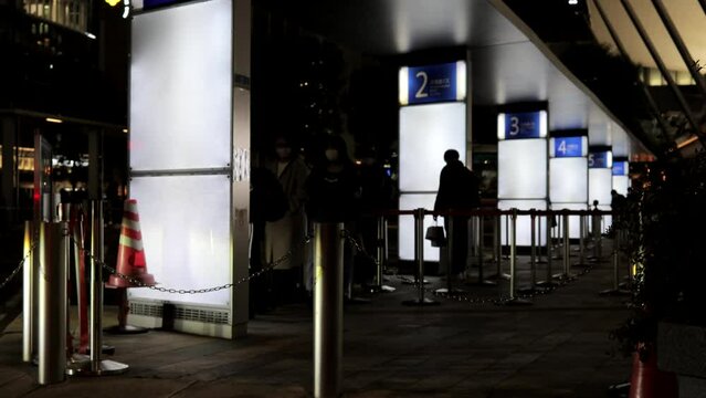 Chiyoda Ward, Tokyo, Japan, December 2022.People waiting for a highway bus at Tokyo Station at night.