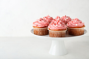Stand with tasty cupcakes for Valentine's Day on white background