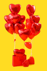 Shopping bag with heart-shaped balloons for Valentine's Day on yellow background