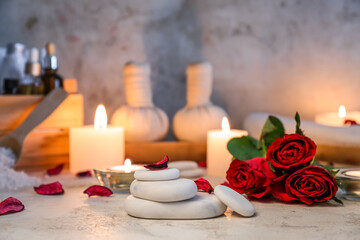 Spa stones with roses and candles on table, closeup. Valentine's Day celebration