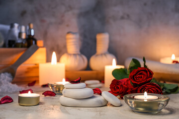 Spa stones with roses and candles on table, closeup. Valentine's Day celebration