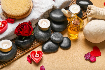 Fototapeta na wymiar Spa composition for Valentine's Day with stones, rose petals and candles on beige background