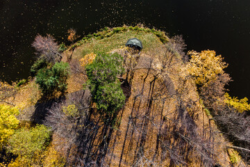 Aerial view of an autumn park surrounded by a pond and a park gazebo on the shore, autumn park...
