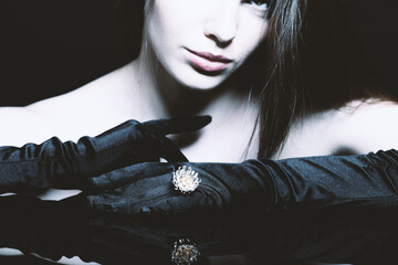 Studio portrait of beautiful and sexy brunette woman with fancy golden ring. Model with black tight...