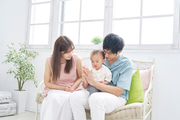  家で赤ちゃんと遊ぶ両親のポートレート