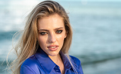 Close up of pretty girl. Beautiful young woman at summer beach. Portrait of beautiful young woman on sea background. Beauty female portrait over blue ocean background. Summer vacation.