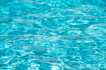 Fototapeta premium Background of blue water in swimming pool with sun reflection, ripple water wave in pool. Clear water background.