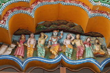 Lord Krishna is holding Govardhana Hill. Stucco over the entrance to a Hindu temple in Puri, Orissa, India.