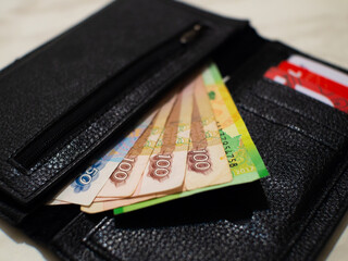 black wallet with money and cards
