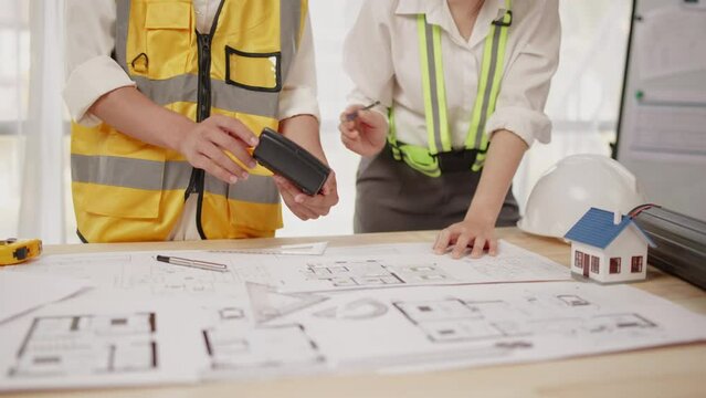 Closeup of hands engineer and architect team discussed about design construction and architectural drawings works within office.