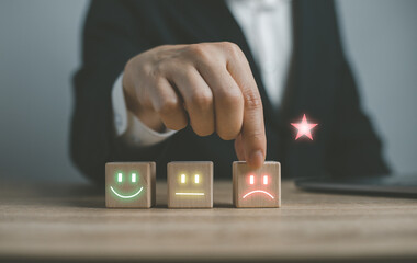 Customer service and Satisfaction concept ,Business people are touching the virtual screen on the happy Smiley face icon to give satisfaction in service. rating very impressed.