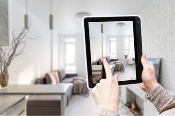 Graphic designer making project of modern living room interior on tablet pc, collage with blueprint mesh furniture models. Panorama. Contemporary residential planning and architecture.