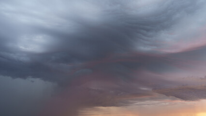 Naklejka na ściany i meble Detail shot of epic storm clouds during sunrise