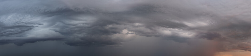 Wide panorama shot of epic storm clouds during sunrise