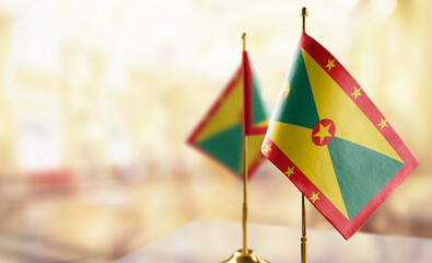Small flags of the Grenada on an abstract blurry background