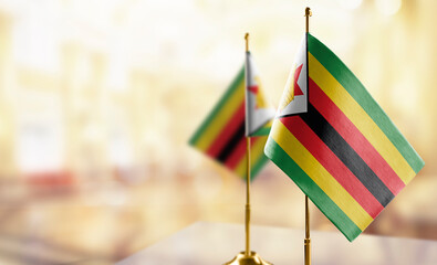 Small flags of the Zimbabwe on an abstract blurry background