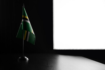 Small national flag of the Dominica on a black background