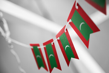 A garland of Maldives national flags on an abstract blurred background