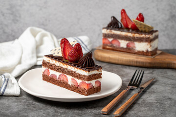 Strawberry and chocolate cake on a dark background. Slice of layered chocolate cake. Bakery cake products. close up