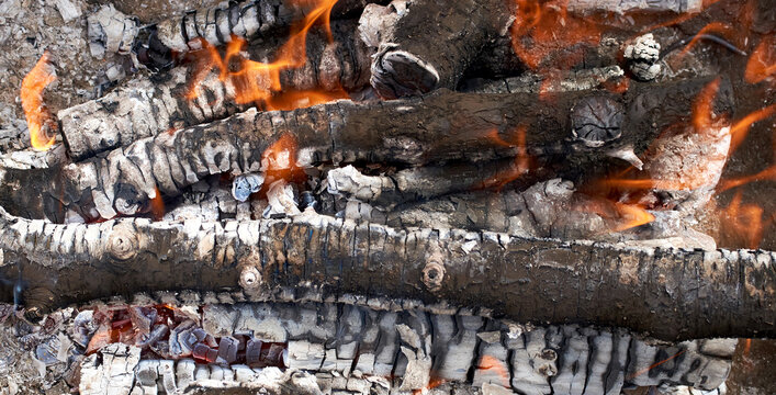 Burning firewood in fire-box of boiler in country cottage.