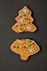 Obraz premium Christmas gingerbread cracked cookie on a dark background .