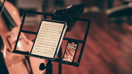 Indoor concert background abstract digital sheet music tablet ipad performing music instruments in...
