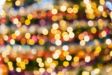 Defocused bokeh light background effect on Christmas tree with balls.
