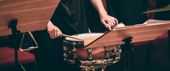 Indoor concert background abstract people performing music instruments in symphony orchestra snare drum