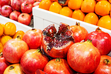 Pomegranate fruits on a grocery store window. Fruit trade wholesale and retail. Close-up