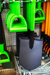 Scoop shovels on the counter in the store. Retail sale of garden tools. Close-up. vertical photo
