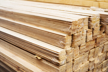 Boards with grooves for assembling walls and various structures. Building material from wood in a warehouse in a store. Close-up