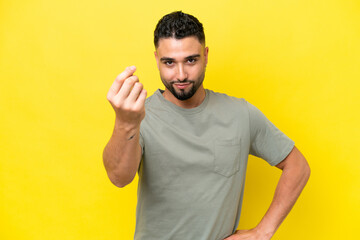 Young Arab handsome man isolated on yellow background making Italian gesture