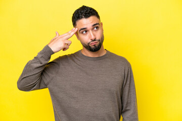 Young Arab handsome man isolated on yellow background with problems making suicide gesture