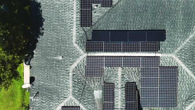 Aerial view of typical american building roof with rows of blue solar photovoltaic panels for producing clean ecological electric energy. Renewable electricity with zero emission concept