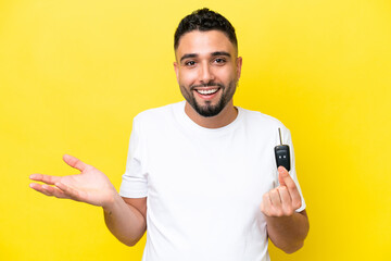 Young Arab man holding car keys isolated on yellow background with shocked facial expression