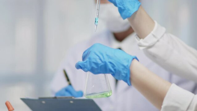 Team scientists is working on chemistry and biology tests and using microscope in laboratory for develop and analysis virus vaccine and pharmacy medicine.