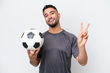 Arab young football player man isolated on white background smiling and showing victory sign