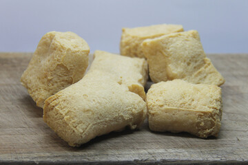 Selective focus picture of  A traditional food from Semarang, Indonesia. Tahu Pong or fried tofu that has hollow inside it, isolated on white background.