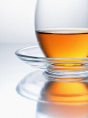 Sunny cup of tea on a light background. Selective focus. Close-up. Vertical. Studio shot.