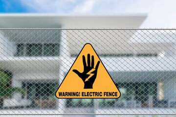 An electric fence warning sign in front of a house. A caution signage to trespassers.