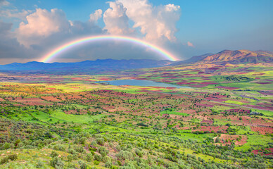Obraz premium Amazing rainbow after the rain in the sky over the field