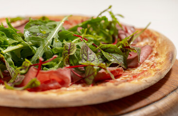 pizza with ham and basil on desk on white background