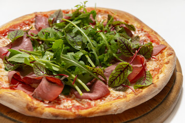 pizza with ham and basil on desk on white background