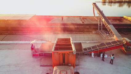 Grain loading to cargo ship. Port grain elevator. Industrial sea trading port bulk cargo zone grain terminal