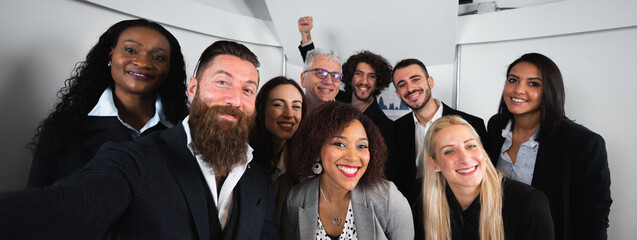 Horizontal banner or header with Group of happy colleagues of diverse ethnicity take a selfie photo with smartphone. Teamwork, cooperation, partnership and unity concept