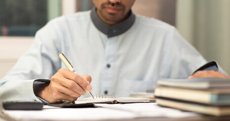 businessman or student writing on notebook while working or learning at workplace
