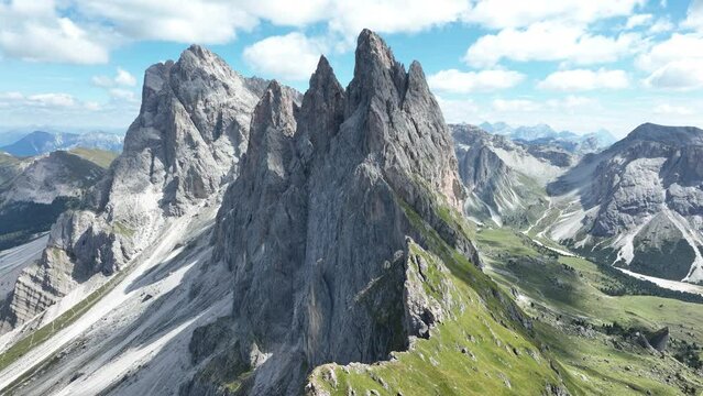 Aerial of majestic mountain range on a sunny summer day. Mountain alp ridge with peak, grass rocks and stone. Aerial drone overhead panorama view. Hiking paradise.