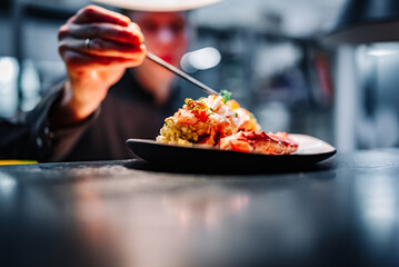 chef decorated plate with food on kitchen