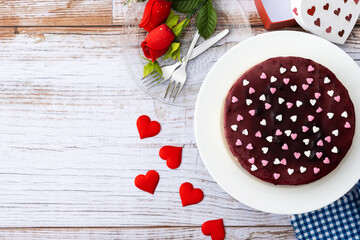 Blueberry cheesecake decorated with sweet hearts on wooden table. Top view. Copy space