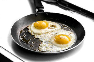 close-up shot of fried eggs on black pan